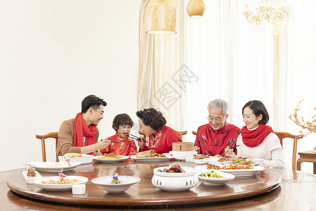 新春年夜饭奶奶夹菜喂小男孩背景图片