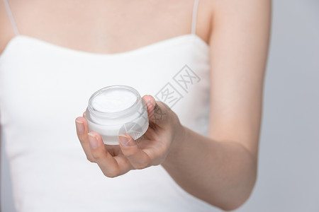女性手里拿着一瓶乳液背景图片