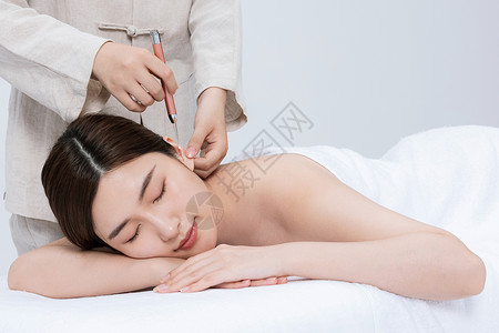 女性趴在床上享受采耳服务背景图片