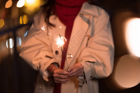 秋冬夜晚美女过圣诞节放烟花棒特写高清图片