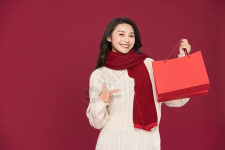 冬季甜美女性过新年拎购物袋背景图片