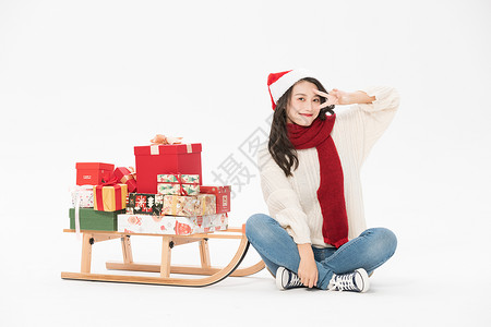 美女用圣诞雪橇载圣诞礼物图片