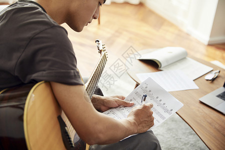 吉他乐谱文艺男青年在家弹吉他背景