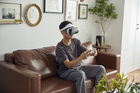 年轻男士居家VR眼镜游戏体验背景图片