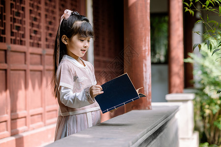 中国风女孩古装汉服儿童公园里看书背景