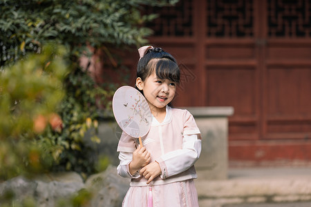 拿扇子的女孩汉服中国风儿童拿扇子逛公园玩耍背景