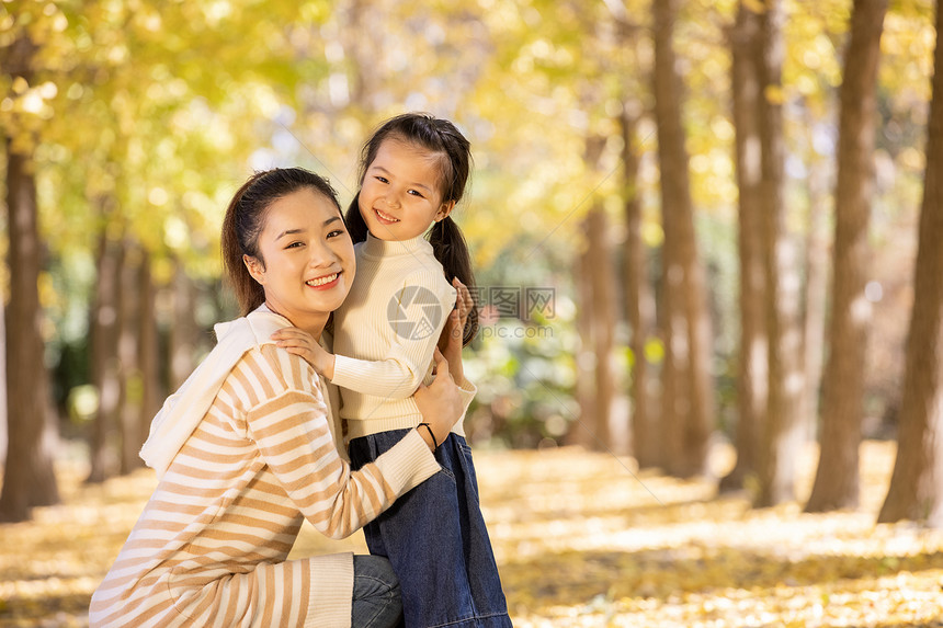 母女两人带着宠物在公园里玩耍图片