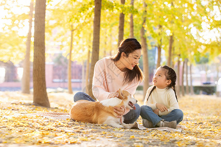 母女两人带着宠物在公园里玩耍图片素材