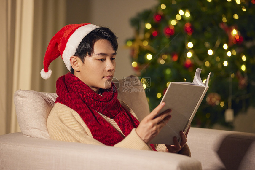 年轻男生圣诞节在家看书图片
