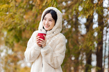 秋冬服装降价秋冬户外手捧咖啡的美女背景