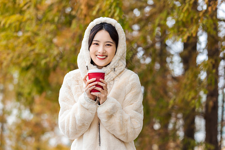 秋冬户外手捧咖啡的美女高清图片