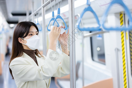 乘车女性用消毒湿巾擦拭地铁的把手背景