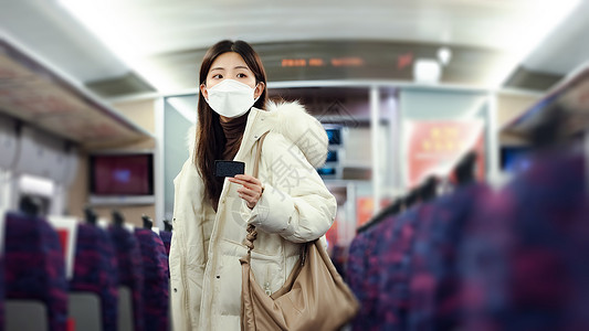 火车车厢内戴口罩的女性在火车车厢里寻找座位背景