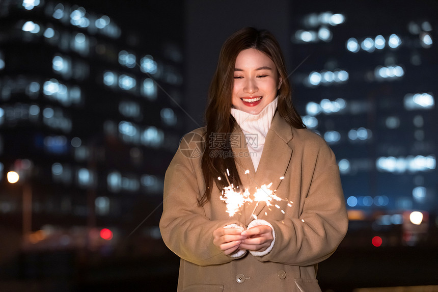 秋冬夜晚美女室外放烟花图片