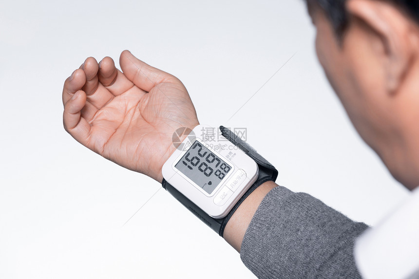 老人使用血压检测仪特写图片