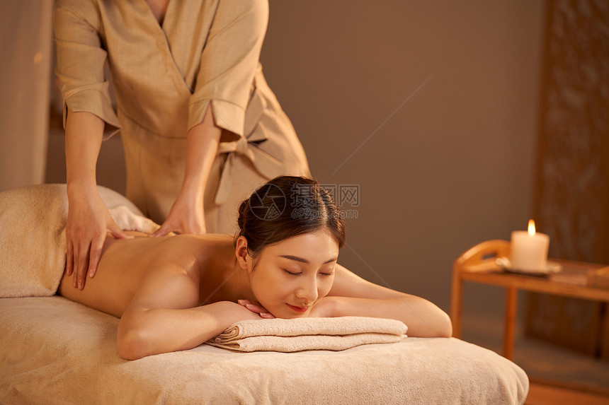 女性spa技师为顾客背部按摩图片