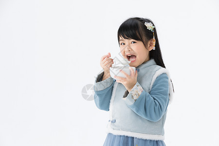 吃汤圆的女孩穿着淡蓝色古装的可爱小女孩吃汤圆背景