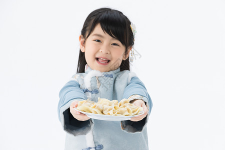 小女孩开心地捧着一盘饺子背景图片