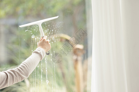 家庭主妇打扫卫生擦玻璃特写背景图片
