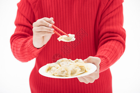 红色毛衣的手夹起饺子高清图片