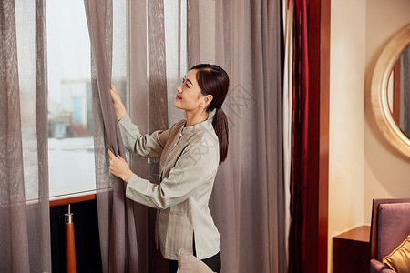 酒店服务保洁员整理窗帘图片素材
