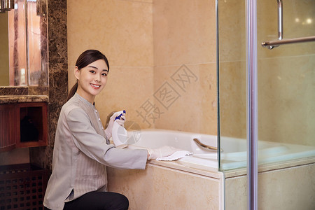 酒店保洁员整理清洁客房洗漱区域浴缸清洁高清图片素材
