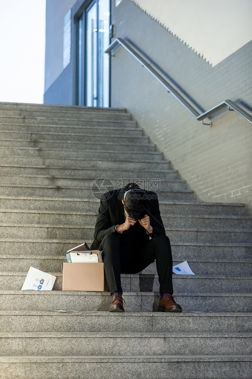 被辞退的商务男性失落的坐在楼梯上图片