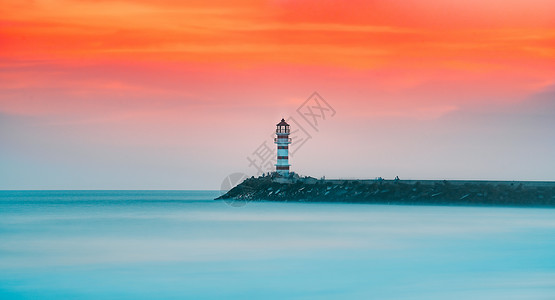 红色风景图晚霞夕阳下的海边灯塔背景