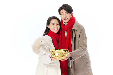 青年夫妻拿金元宝欢乐庆祝新年背景图片