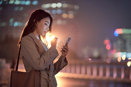 深夜加班的都市女性使用手机打车图片