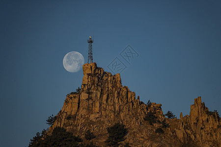 岩石塔月亮与高山铁塔背景