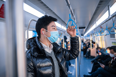 春节通知放假戴口罩乘地铁的人站在地铁上的男性背景