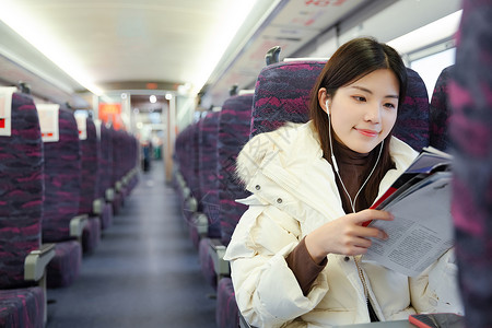 报纸春节素材坐在火车车厢看报纸的女性背景