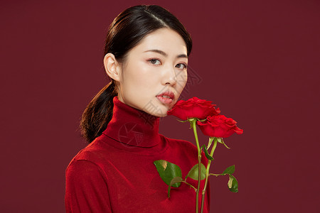时尚美妆女性拿红玫瑰花背景图片