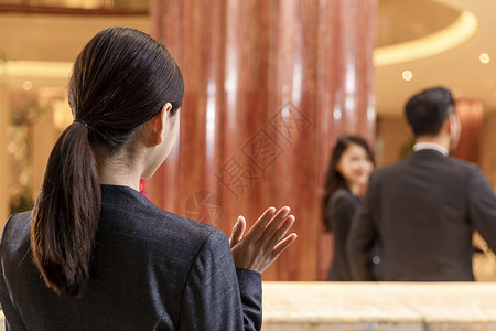 宾馆服务员酒店前台挥手向旅客告别背景