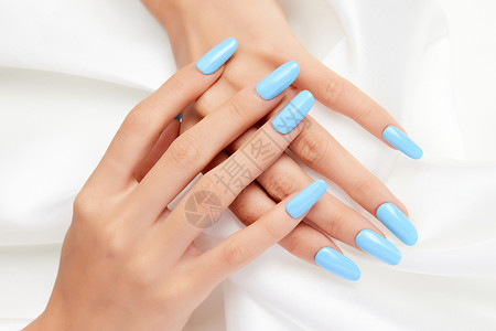 女性纯色蓝色美甲特写握着丝绸指甲油高清图片素材