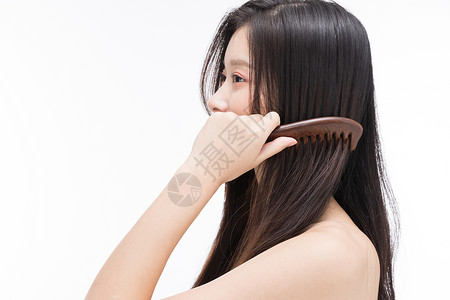 年轻女性使用梳子梳头发背景图片