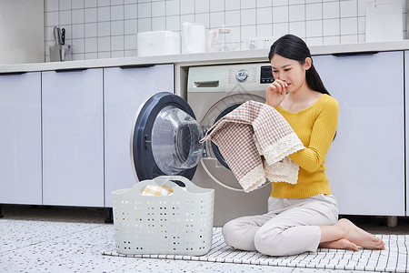 衣服女家庭主妇清洗衣物闻脏衣物背景