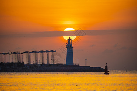 大海力量灯塔与海上日出背景