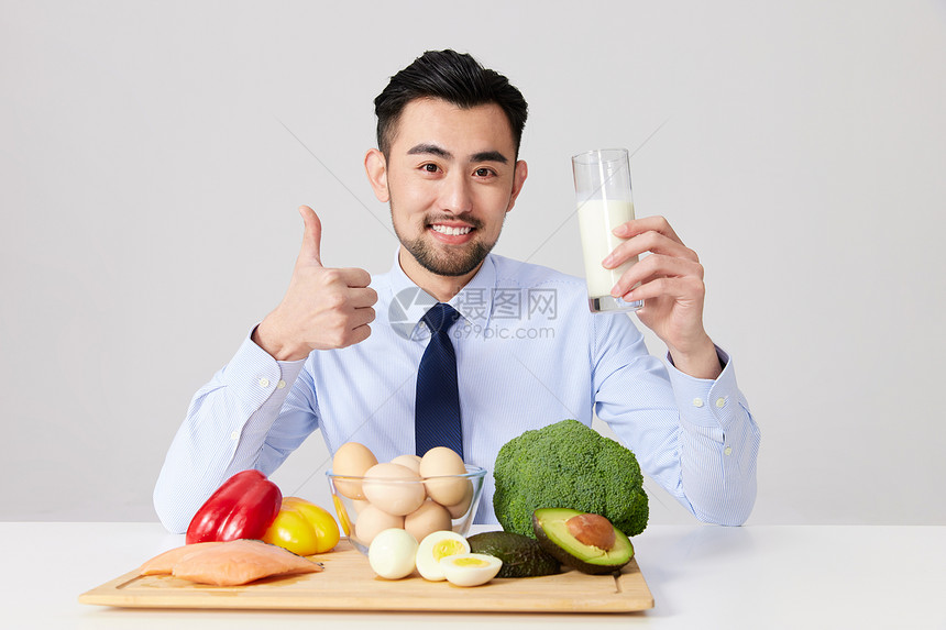 健康饮食的职场男士拿着一杯牛奶点赞图片