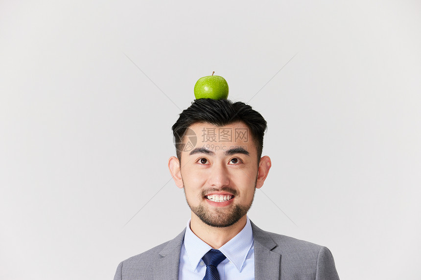 男性头顶着一颗苹果图片