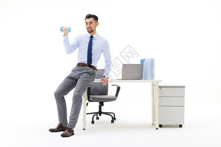 男性在办公室靠着桌子举哑铃图片