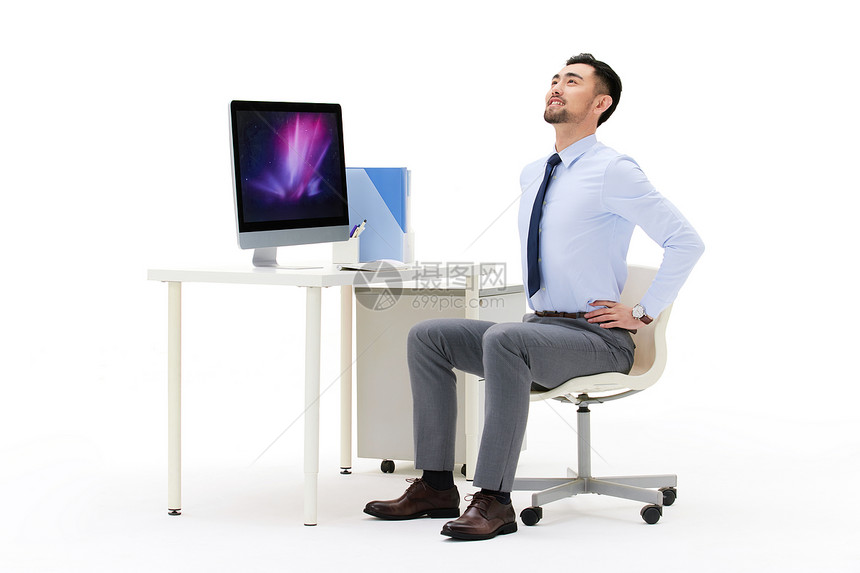 职场男性坐在办公桌前舒展身体图片