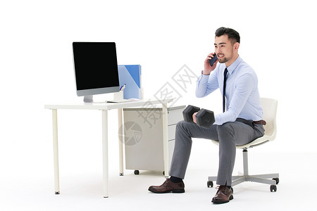 男性在办公室边打电话边工作图片