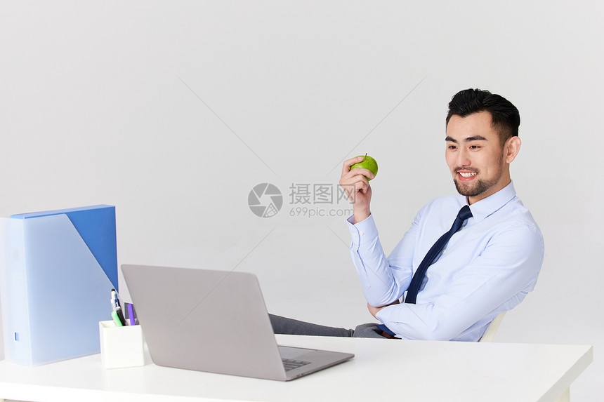 职场男士办公时吃青苹果图片