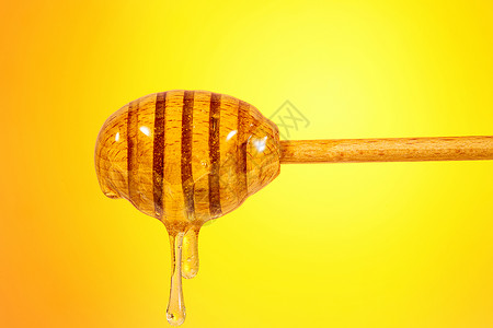 黄色背景前的蜂蜜高清图片