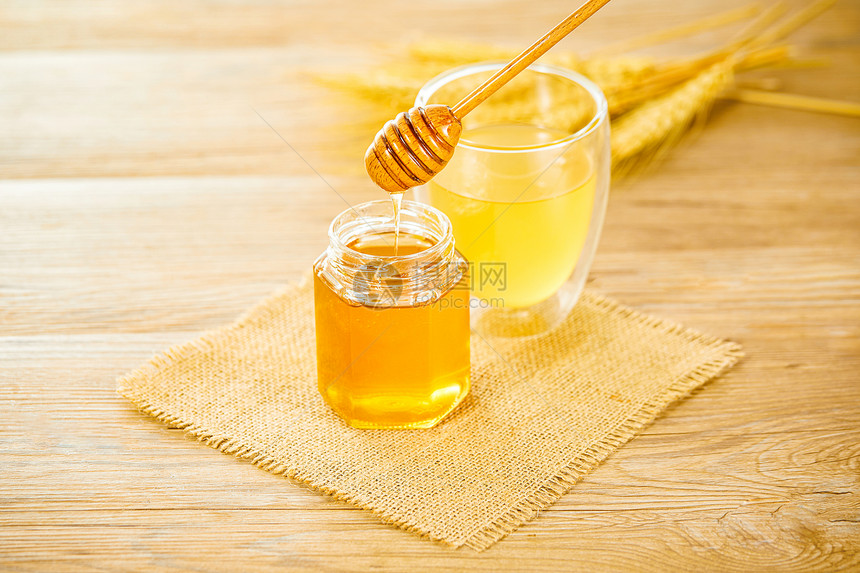 木桌上的蜂蜜和蜂蜜水图片