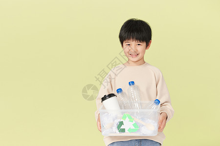 抱着可回收物的小男孩高清图片