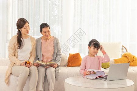 奶奶与妈妈客厅辅导女孩学习东亚人高清图片素材