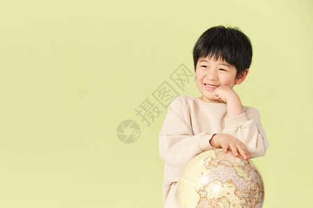 抱着地球模型笑的小男孩背景图片